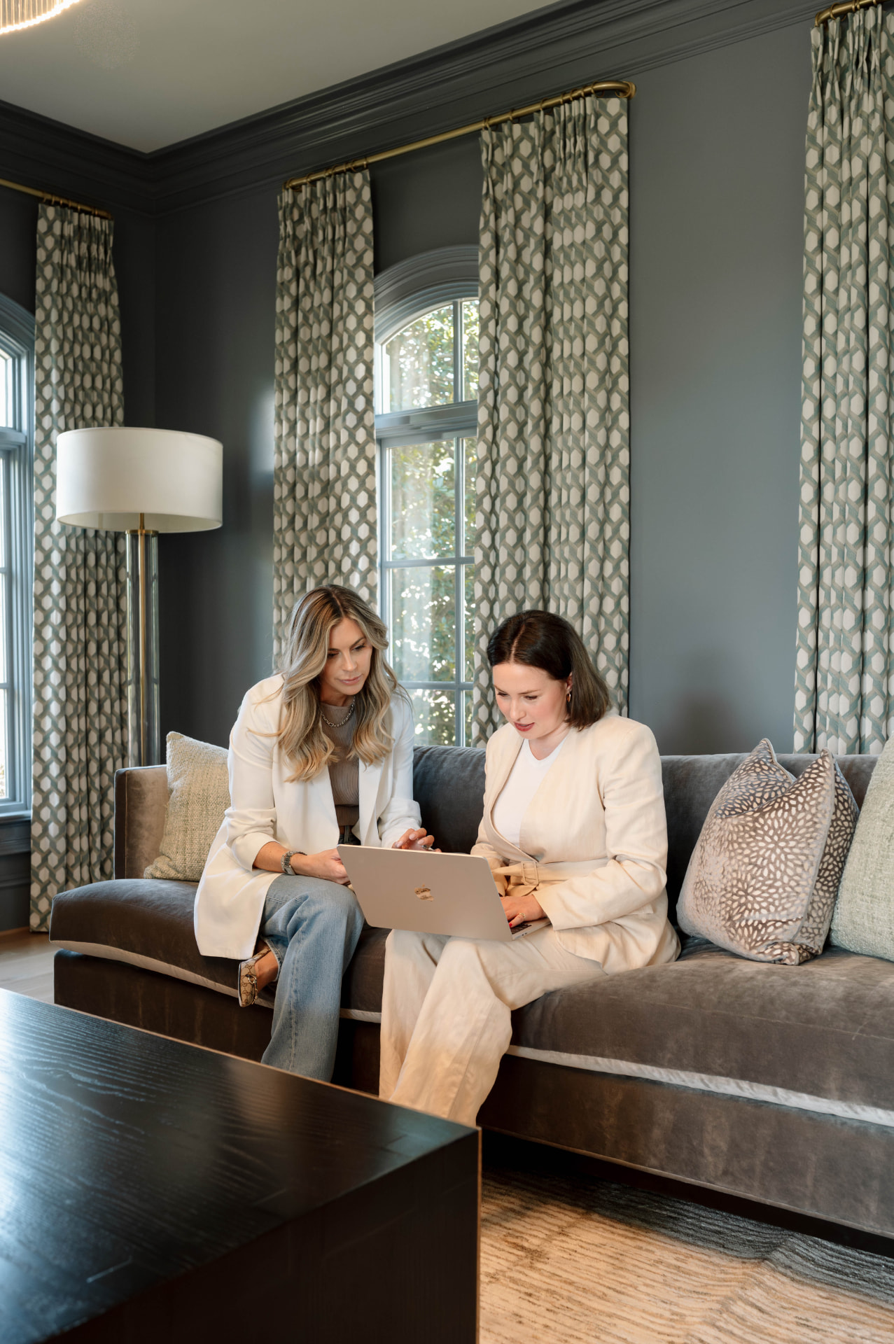 Claire Guentz and Julia Sawchak reviewing listings together on a sofa